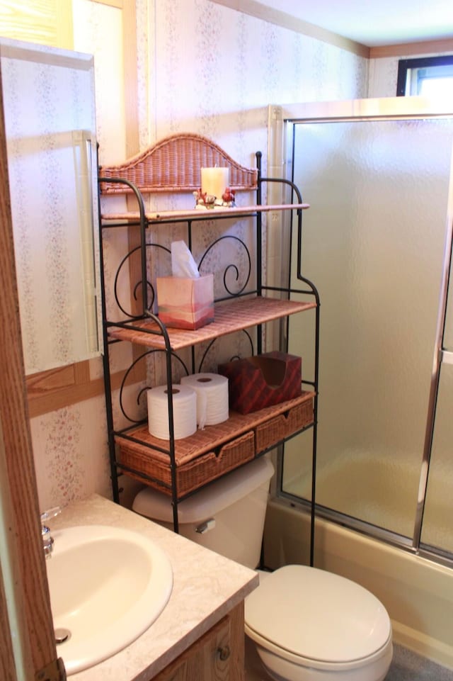 45 Ravine Ridge Dr, Delaware, OH 43015 - bathroom with bath / shower combo with glass door, vanity, wallpapered walls, and toilet