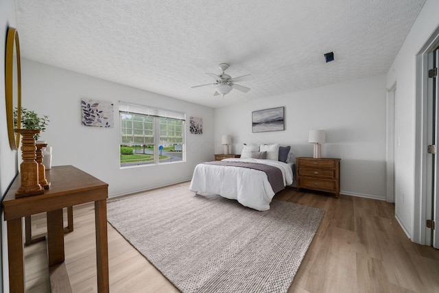 155 Arrowfeather Ln, Lewis Center, OH 43035 - bedroom with light wood-style flooring, a textured ceiling, a ceiling fan, and baseboards