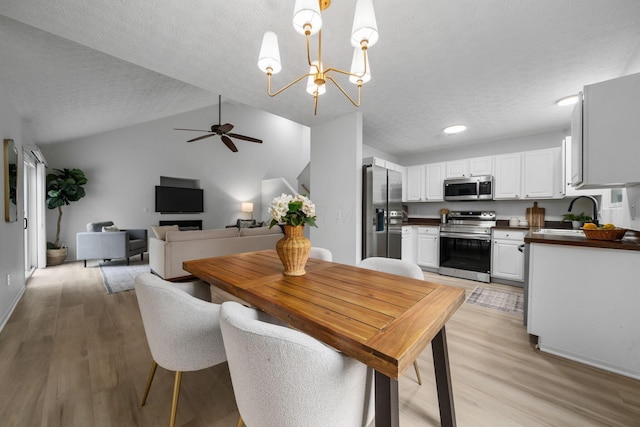 155 Arrowfeather Ln, Lewis Center, OH 43035 - dining room with light wood-type flooring, ceiling fan, vaulted ceiling, a textured ceiling, and a chandelier
