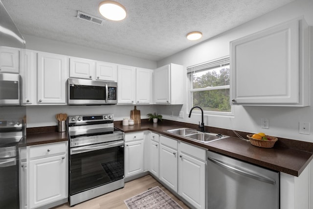 155 Arrowfeather Ln, Lewis Center, OH 43035 - kitchen with appliances with stainless steel finishes, a sink, dark countertops, and a textured ceiling
