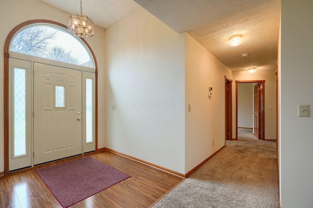 entrance foyer featuring a chandelier, wood finished floors, and baseboards
