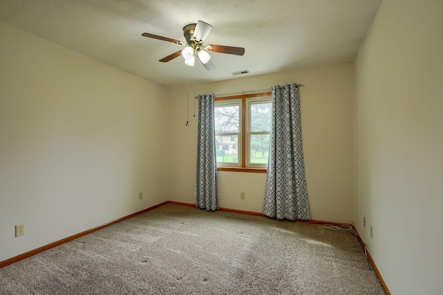 empty room with visible vents, baseboards, a ceiling fan, and carpet floors