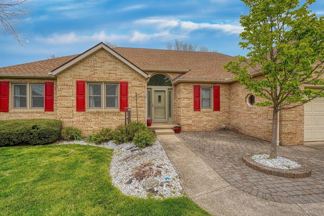 single story home with roof with shingles, driveway, a front lawn, and brick siding