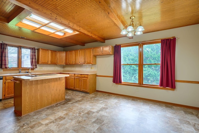 kitchen featuring beamed ceiling, light countertops, an inviting chandelier, and stone finish flooring