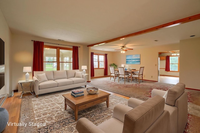 living area with baseboards, light wood-style flooring, visible vents, and a ceiling fan