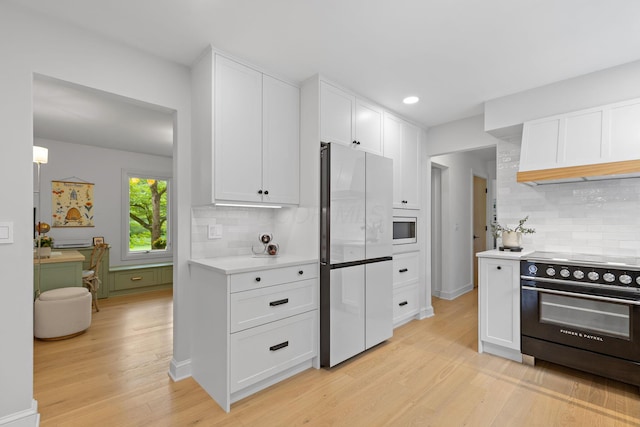 8019 Clouse Rd, New Albany, OH 43054 - kitchen featuring stainless steel appliances, light countertops, white cabinets, light wood finished floors, and backsplash