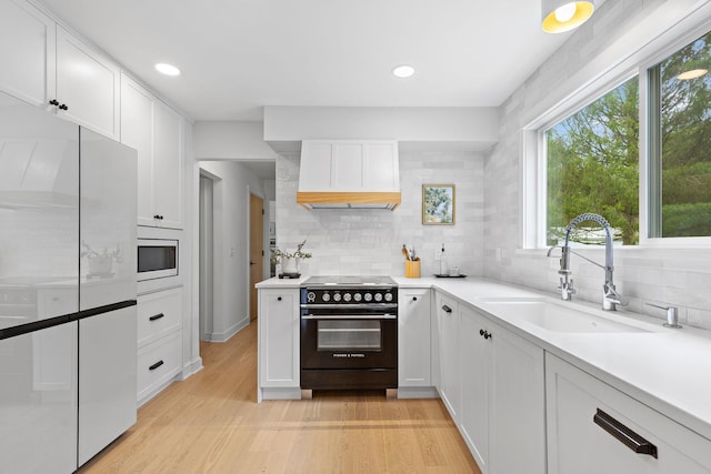 8019 Clouse Rd, New Albany, OH 43054 - kitchen with stainless steel range with electric cooktop, freestanding refrigerator, premium range hood, built in microwave, and decorative backsplash