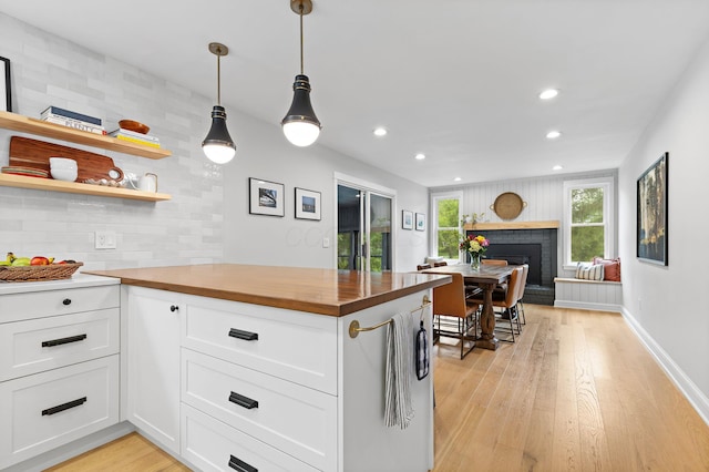 8019 Clouse Rd, New Albany, OH 43054 - kitchen featuring wood counters, a fireplace, light wood finished floors, white cabinets, and recessed lighting
