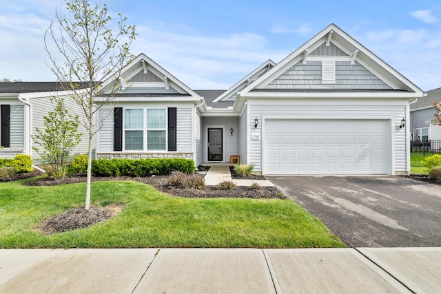 view of front of home with stone siding, an attached garage, driveway, and a front yard