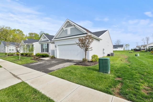 view of front of house featuring an attached garage, driveway, and a front yard
