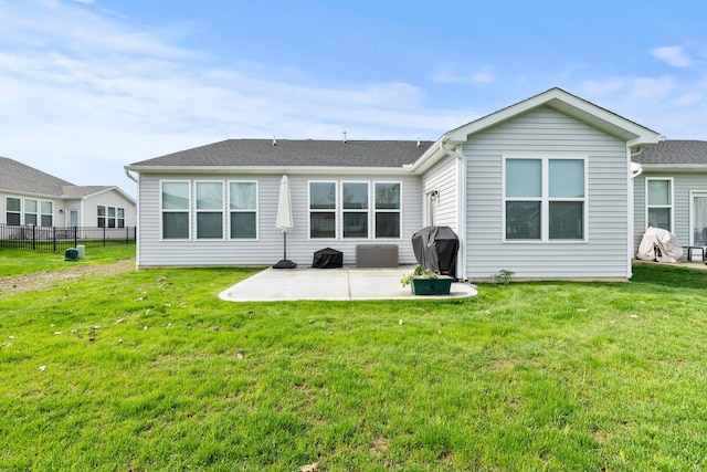 back of property with a lawn, a patio, and fence