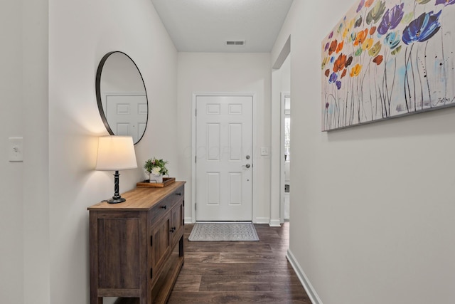 doorway to outside featuring dark wood-style flooring, baseboards, and visible vents