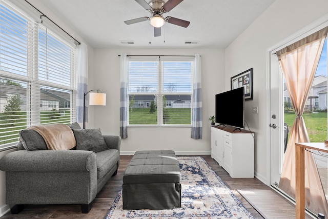 living room featuring a ceiling fan, visible vents, and a healthy amount of sunlight