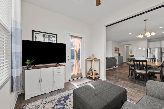 living area featuring recessed lighting, baseboards, wood finished floors, and ceiling fan with notable chandelier