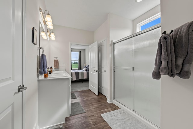 ensuite bathroom featuring ensuite bathroom, a shower stall, wood finished floors, and a wealth of natural light