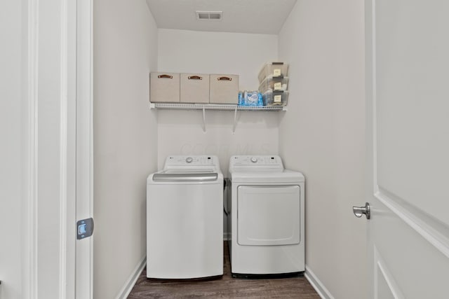 clothes washing area with laundry area, dark wood-style flooring, visible vents, baseboards, and separate washer and dryer