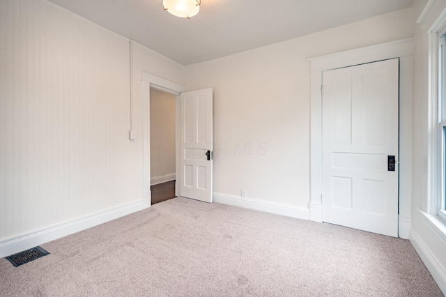unfurnished bedroom featuring baseboards, visible vents, and carpet floors