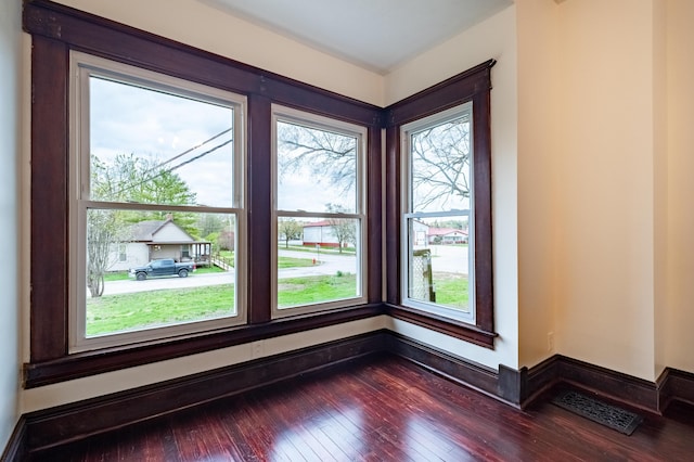 spare room featuring dark wood-style flooring and visible vents