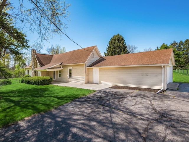 88 Tallman St, North Lewisburg, OH 43060 - ranch-style home with a patio, a chimney, a shingled roof, and a front lawn
