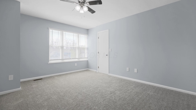 carpeted spare room with ceiling fan, baseboards, and visible vents