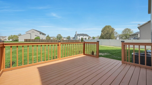 deck featuring a residential view, a lawn, and a fenced backyard