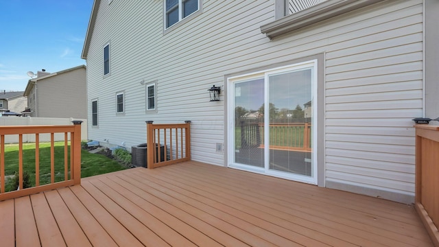 wooden deck featuring a lawn and central AC unit