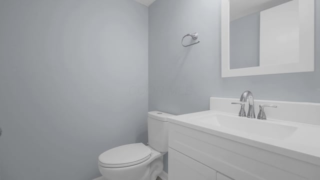 half bathroom featuring toilet and vanity