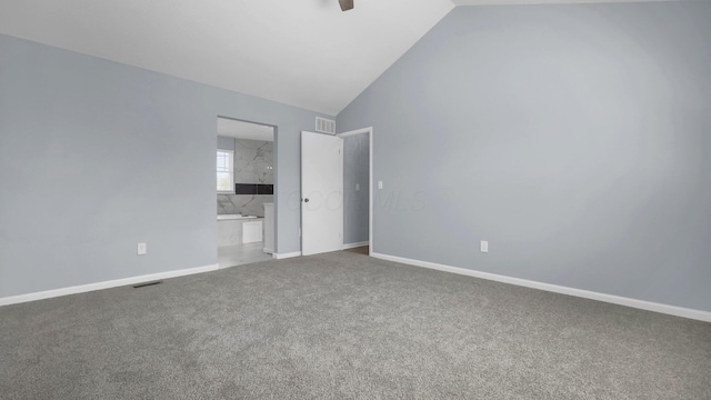 unfurnished bedroom featuring ensuite bath, vaulted ceiling, visible vents, and carpet