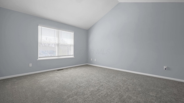 spare room with lofted ceiling, visible vents, carpet flooring, and baseboards