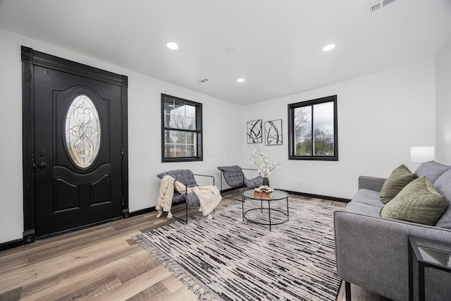 living area with recessed lighting, plenty of natural light, light wood finished floors, and visible vents