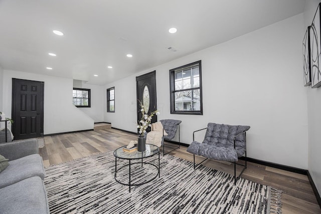 living room with visible vents, baseboards, recessed lighting, and wood finished floors