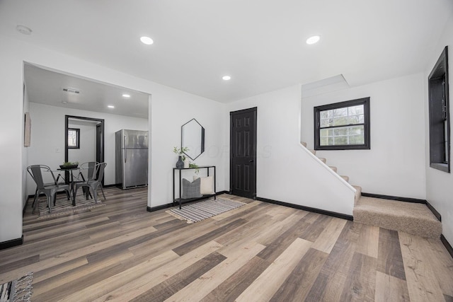 interior space with recessed lighting, baseboards, stairs, and wood finished floors