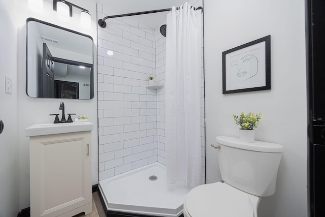 full bathroom with a shower stall, vanity, visible vents, and toilet