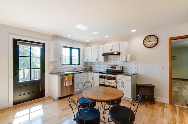 9730 Lancaster Kirkersville Rd NW, Baltimore, OH 43105 - kitchen with tasteful backsplash, white cabinetry, under cabinet range hood, light wood-style floors, and appliances with stainless steel finishes