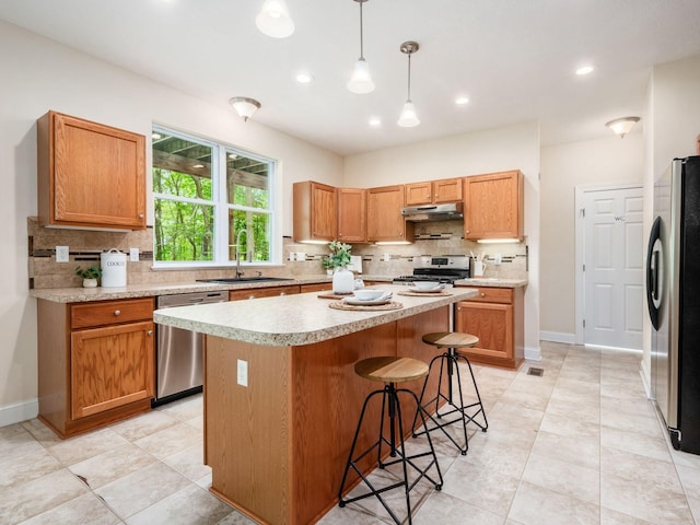 9684 Shawnee Trl, Powell, OH 43065 - kitchen featuring a sink, appliances with stainless steel finishes, under cabinet range hood, decorative backsplash, and recessed lighting