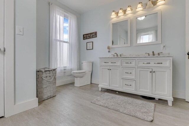 328 Pearl St, Jackson, OH 45640 - bathroom with wood finished floors, a sink, double vanity, baseboards, and toilet