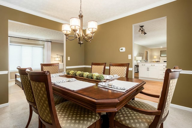 dining space with ornamental molding, baseboards, a notable chandelier, and light colored carpet
