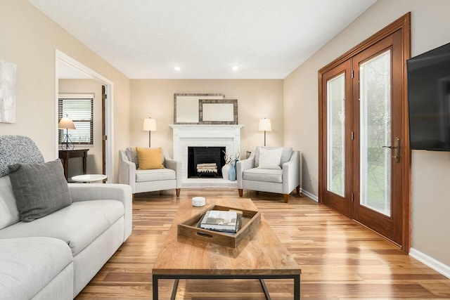 living room featuring recessed lighting, wood finished floors, a brick fireplace, and baseboards