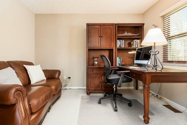 office space featuring baseboards and light carpet