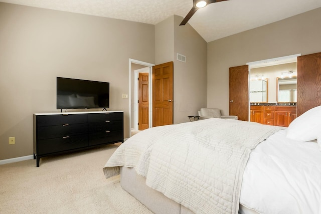 bedroom featuring vaulted ceiling, ensuite bathroom, light carpet, baseboards, and visible vents