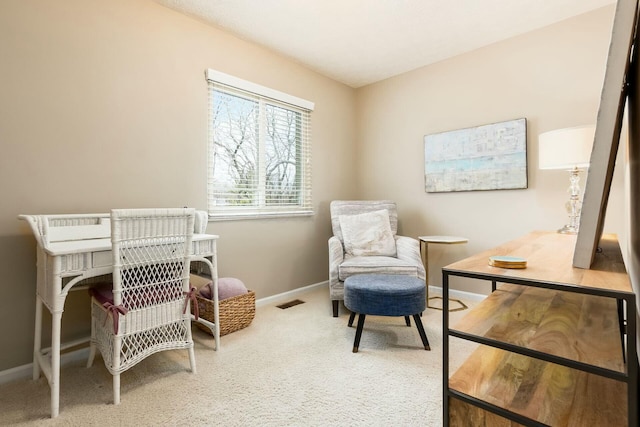 sitting room with carpet floors, visible vents, and baseboards