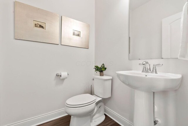 2418 Home Rd, Powell, OH 43065 - half bathroom with baseboards, toilet, wood finished floors, and a sink