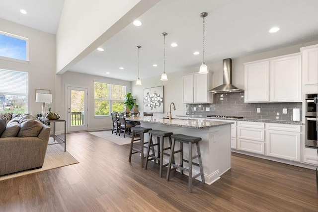 2418 Home Rd, Powell, OH 43065 - kitchen with wall chimney exhaust hood, decorative backsplash, open floor plan, and dark wood-style flooring