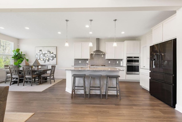 2418 Home Rd, Powell, OH 43065 - kitchen featuring recessed lighting, a kitchen breakfast bar, wall chimney exhaust hood, tasteful backsplash, and appliances with stainless steel finishes