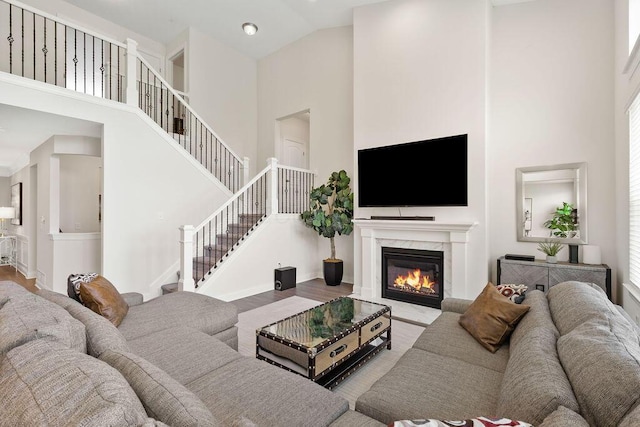 2418 Home Rd, Powell, OH 43065 - living room featuring high vaulted ceiling, wood finished floors, stairs, and a premium fireplace