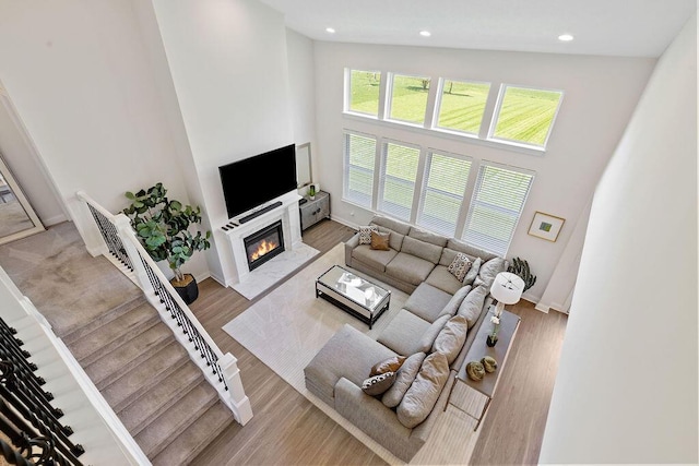 2418 Home Rd, Powell, OH 43065 - living area featuring recessed lighting, a high ceiling, wood finished floors, baseboards, and a glass covered fireplace