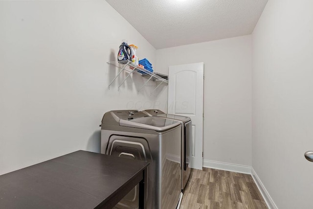 2418 Home Rd, Powell, OH 43065 - washroom with washing machine and clothes dryer, wood finished floors, a textured ceiling, baseboards, and laundry area