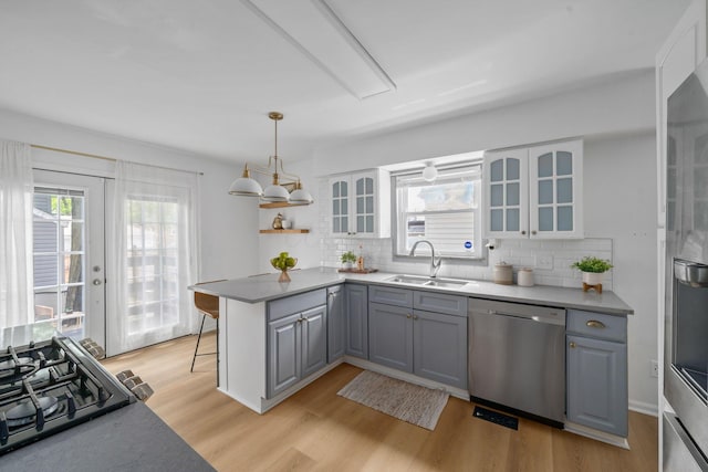 876 Palmer Rd, Columbus, OH 43212 - kitchen with decorative backsplash, a sink, light wood-style flooring, gray cabinetry, and stainless steel appliances