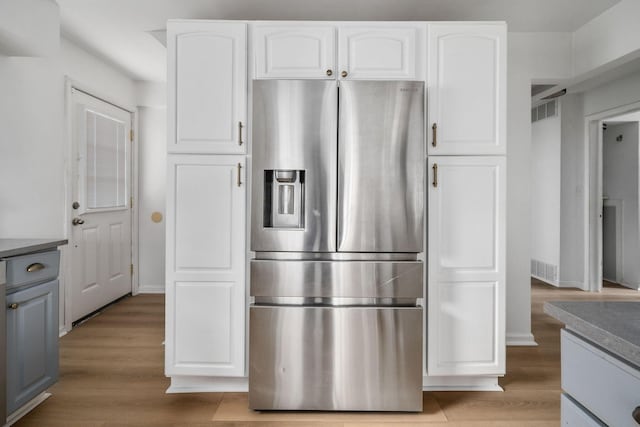 876 Palmer Rd, Columbus, OH 43212 - kitchen with stainless steel fridge, baseboards, white cabinets, and visible vents