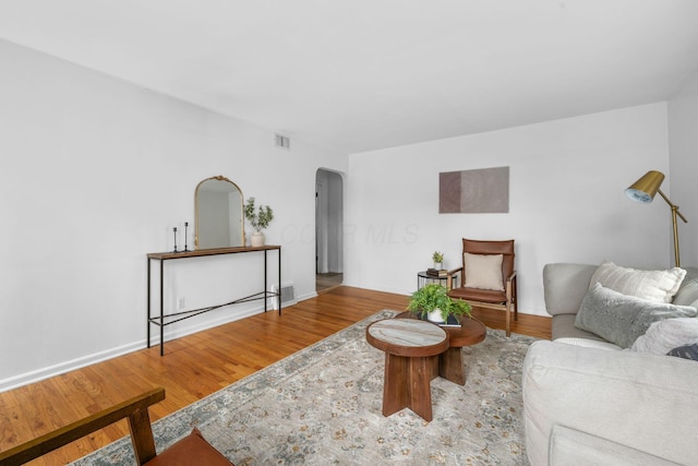 876 Palmer Rd, Columbus, OH 43212 - living room featuring arched walkways, baseboards, wood finished floors, and visible vents